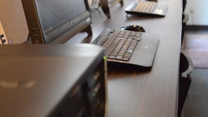 A row of laptops on a desk with a window in the background. - Hotel Maruchu Classico (Tokyo)