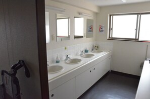 A bathroom with three sinks, a mirror, and a window. - Hotel Maruchu Classico (Tokyo)