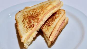 Un panino alla griglia su un piatto bianco.