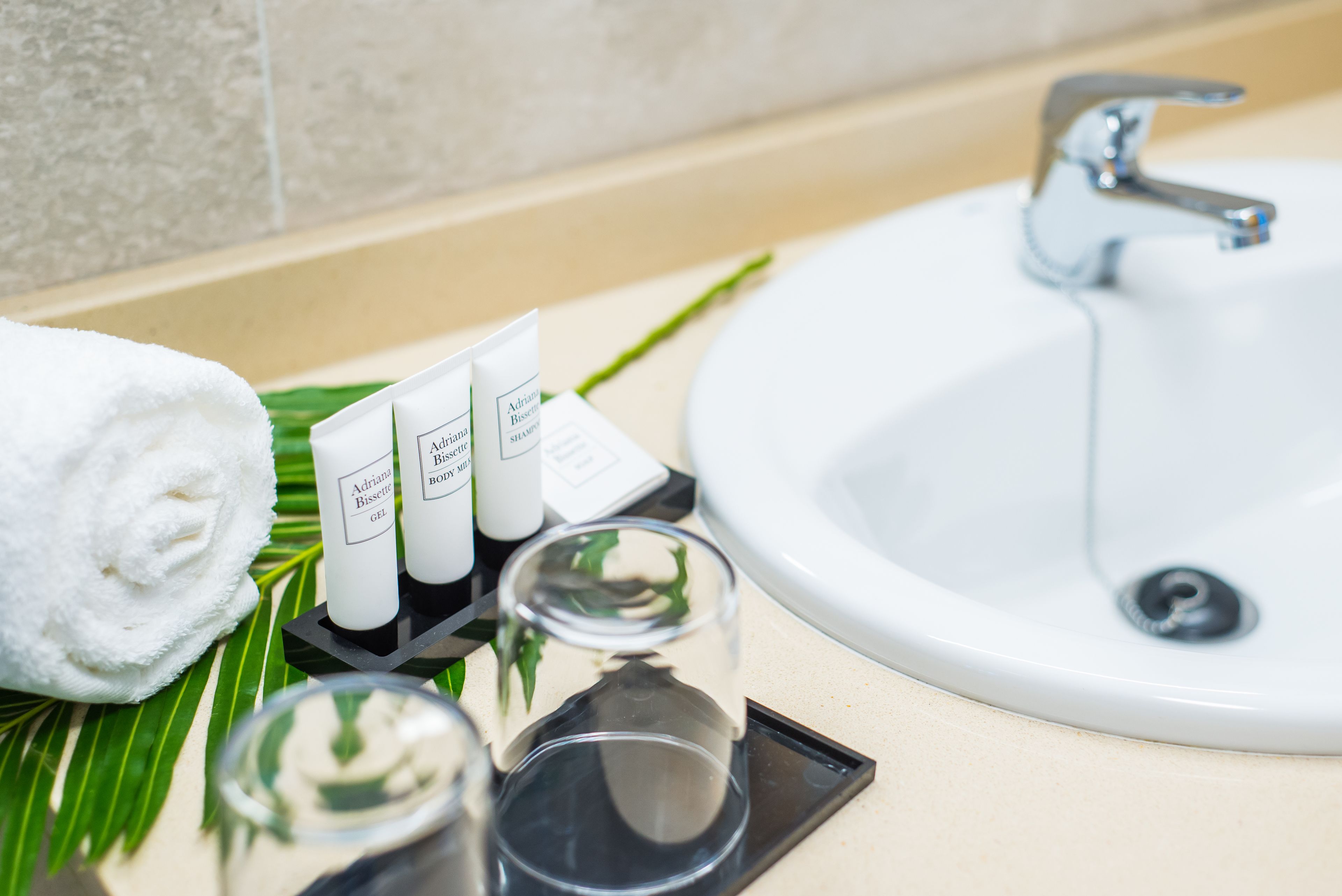 A bathroom with a white sink, a towel, and toiletries.