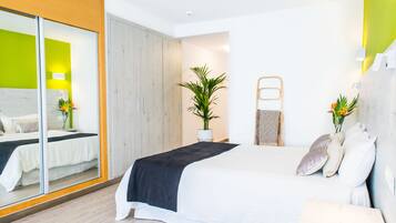 Un dormitorio moderno con una cama grande, un espejo, una planta en maceta y un armario de madera.
