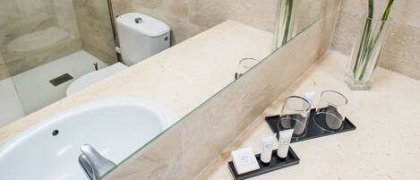 A modern bathroom with a glass-enclosed shower, a white sink, and a vanity with a mirror.