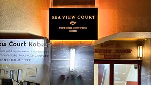 Een hotelentree met een bord waarop staat 'SEA VIEW COURT' en 'HOTEL EAVIN COURT KOBE'.