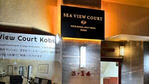 Naamplaatje voor Sea View Court, met een zwarte achtergrond en gouden letters. Daaronder een kleiner bordje met tekst in het Engels en Japans, en het nummer '3-14' als unitnummer.