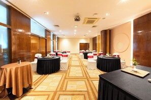 A hotel conference room with multiple round tables, chairs, and a carpeted floor. - MGM Mark Whitefield (Bengaluru)