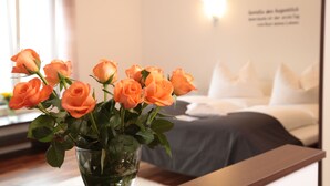 A room with a bed, a bedside table, and a wall with a light fixture. - Hotel am Marktplatz (Gangkofen)