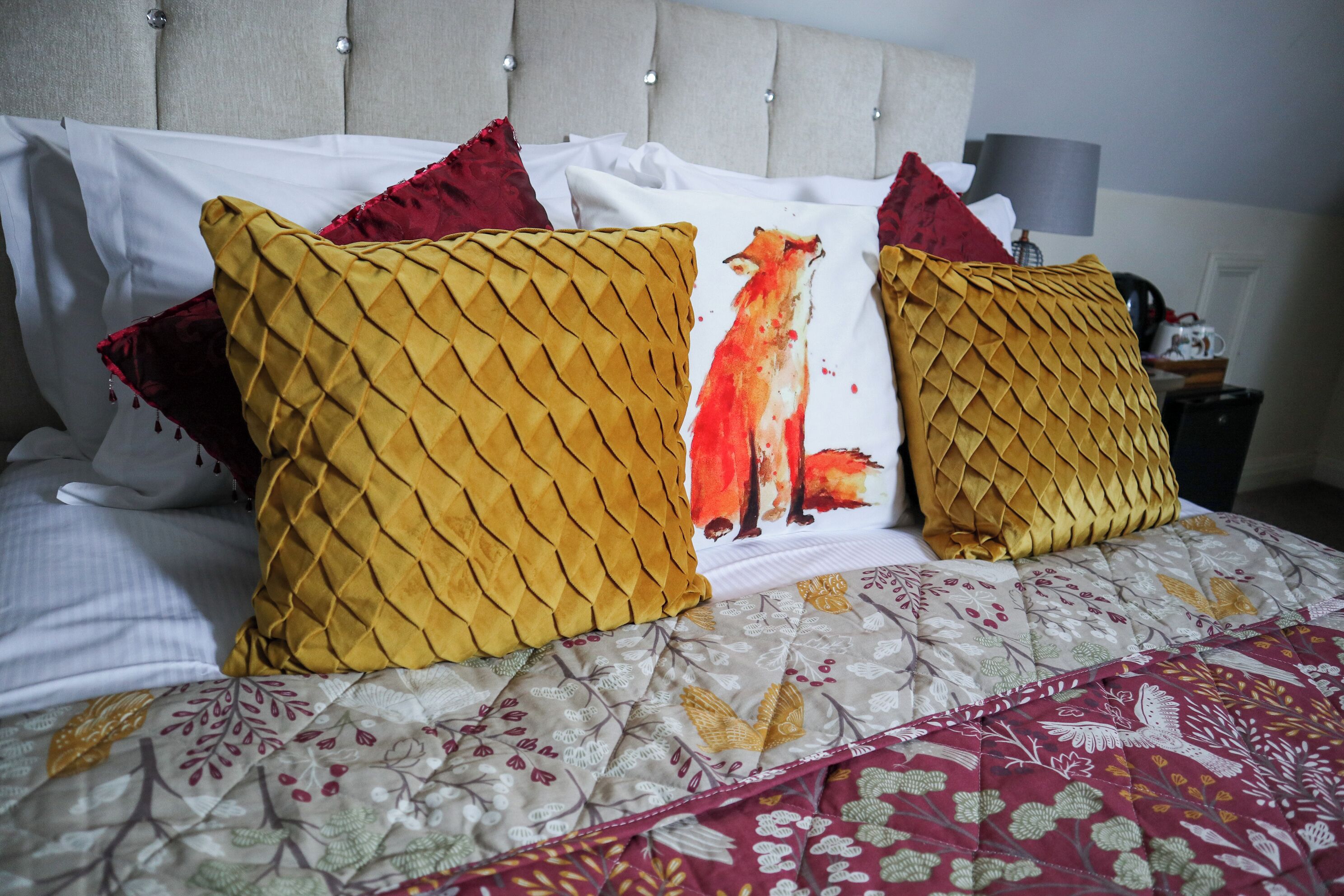 A bed with patterned bedding and decorative pillows.