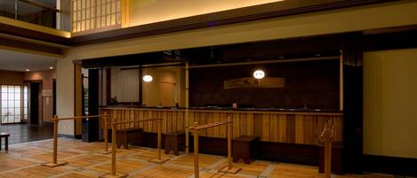 Un interior en estilo japonés tradicional, con suelo de tatami, muebles de madera y puertas correderas.