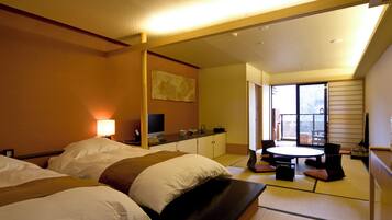 Una habitación de hotel con dos camas, un escritorio, una silla y un ventanal grande.
