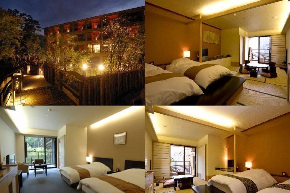A hotel with a traditional architectural style, featuring a courtyard with a wooden staircase leading to the upper floors. The rooms have a simple layout with a bed, bedside table, and a window providing a view of the courtyard.