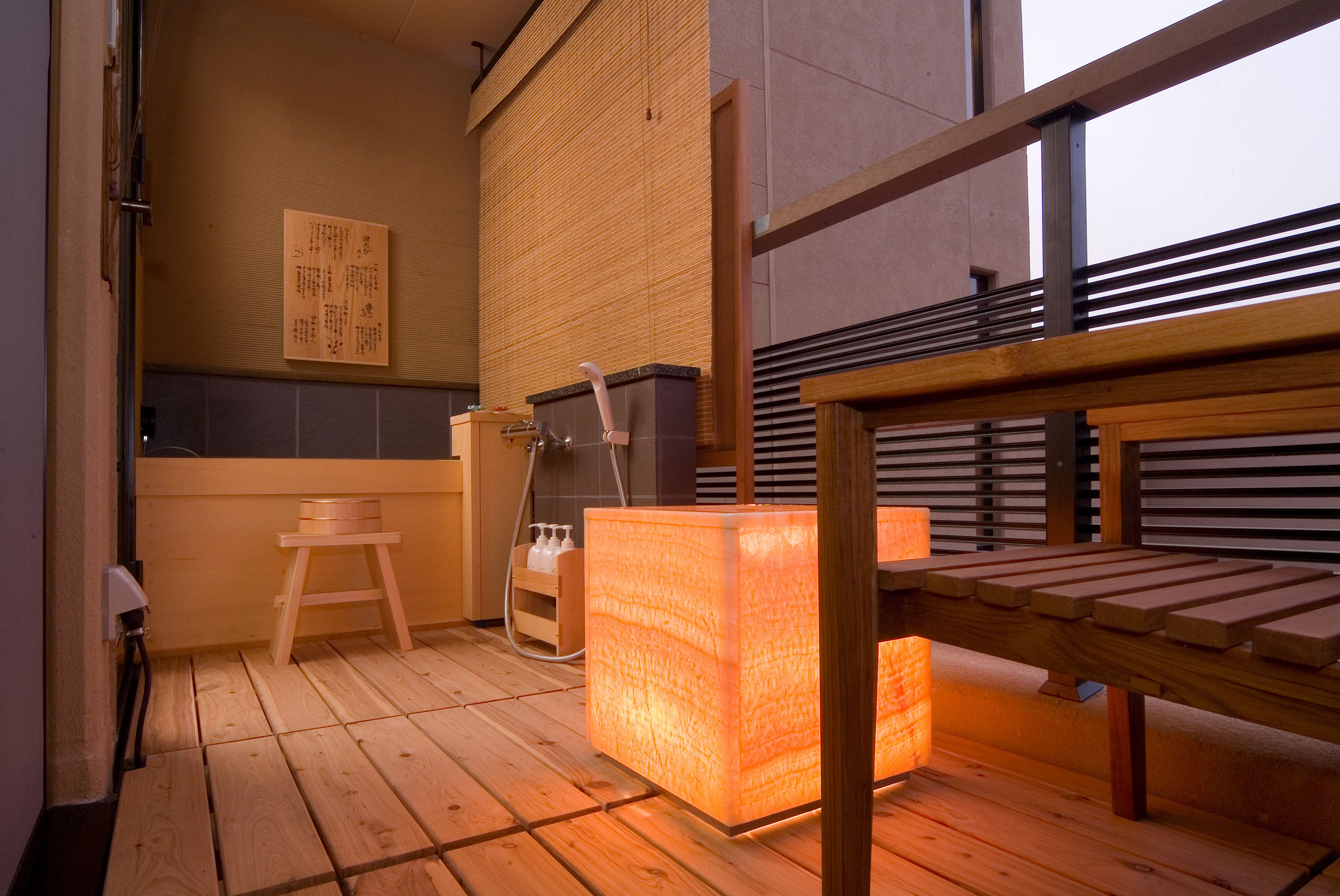 Ett rum med trägolv, en träbänk, ett massagebord och en massagestol.