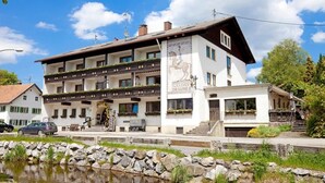 A two-story building with a balcony, a sign reading "GASTHOF DRAGONIER," and a stone wall in front. - Hotel Restaurant Dragoner (Peiting)