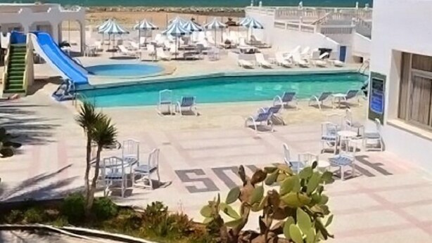 A resort pool area with a slide, sun loungers, and umbrellas. - Hôtel Solymar Beach (Soliman)