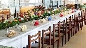 A long dining table set with chairs, surrounded by floral arrangements and table settings. - Hôtel Solymar Beach (Soliman)