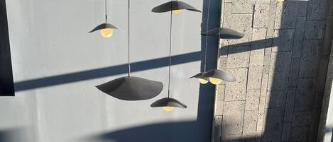 Un área de descanso moderna con un sofá curvo, una mesa de centro redonda y una mesita auxiliar con una planta.