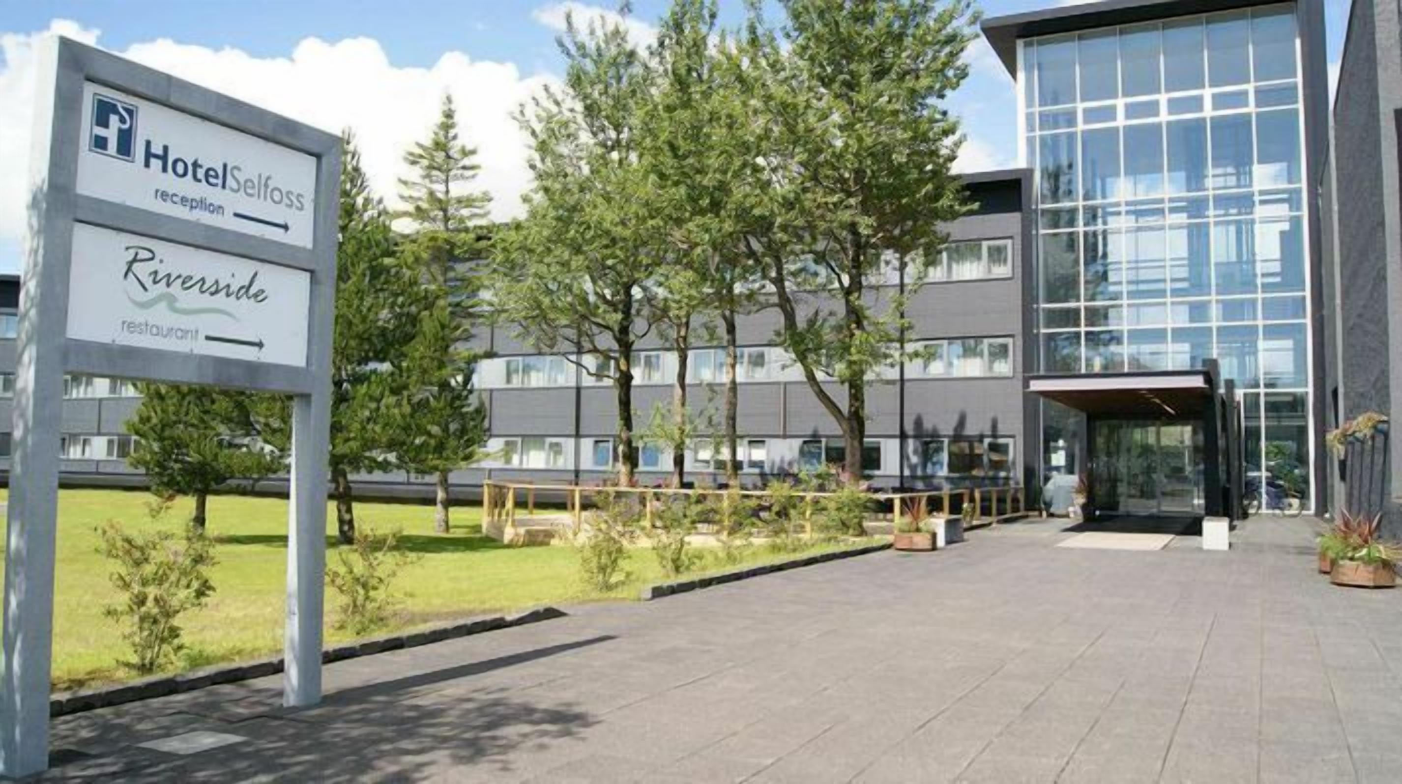 Un espace d’accueil d’hôtel avec une enseigne indiquant l’hôtel Selfoss et le restaurant Riverside.