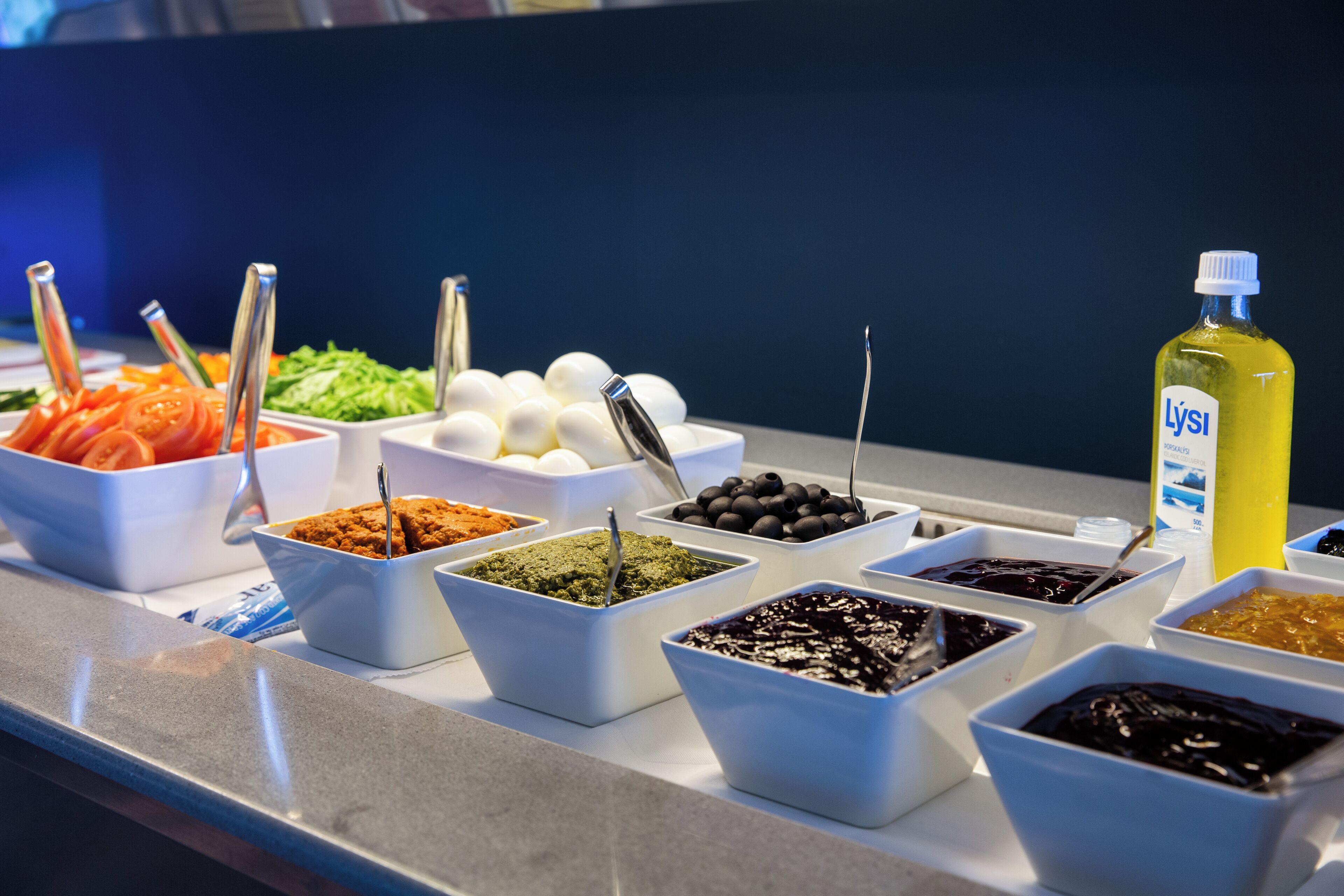 A buffet with various food items and condiments.
