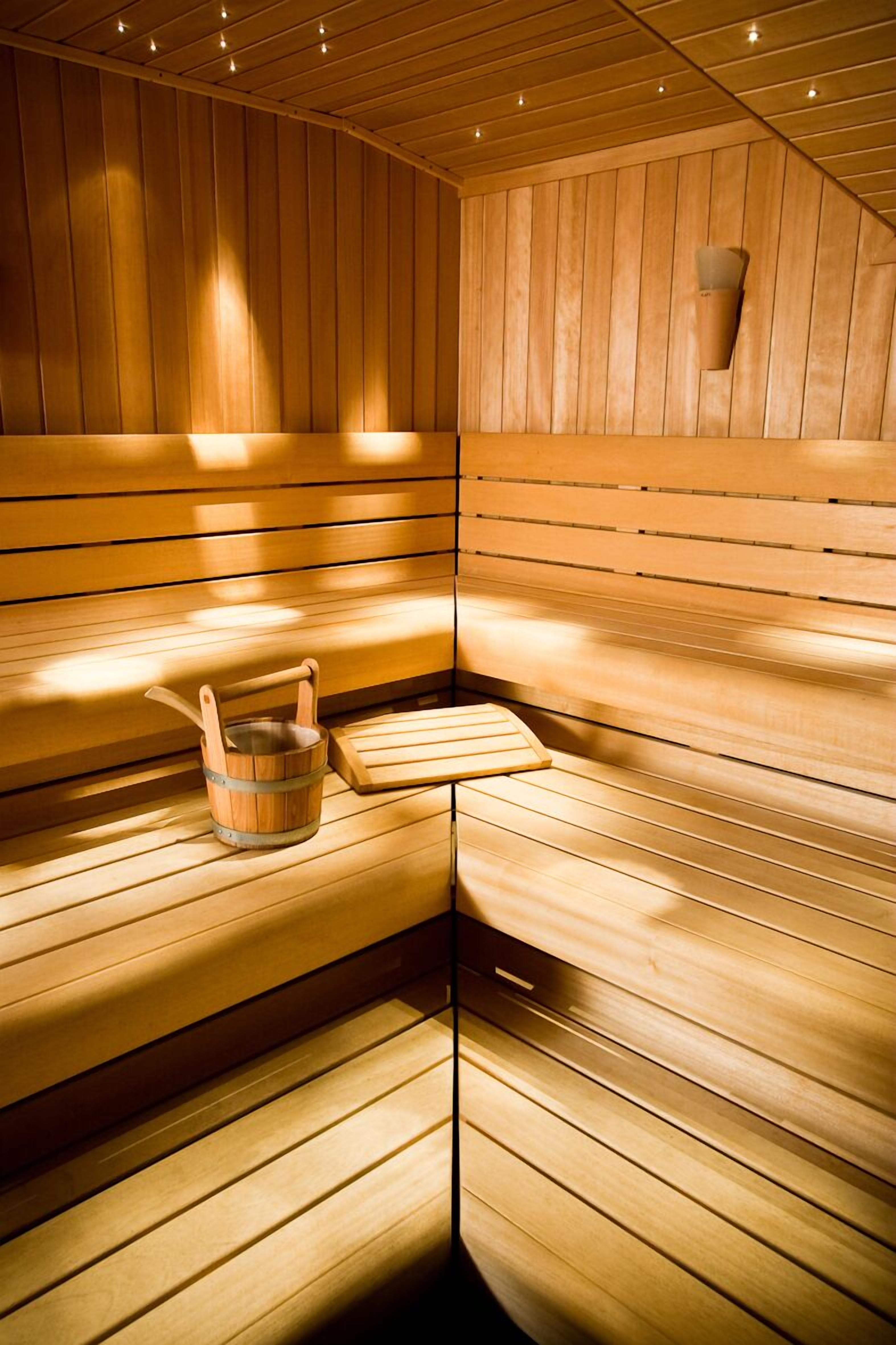 Una sauna con panche in legno e un piccolo tavolo con un catino.