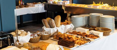 A buffet with various breads, pastries, and a toaster.