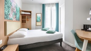 A hotel room with a bed, a desk, a chair, a wardrobe, and a window with curtains. - Hotel de Paris (Boulogne-Billancourt)