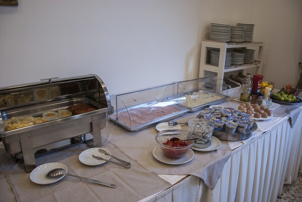 Un buffet proposant une variété de plats, notamment des œufs, de la viande et des produits laitiers.