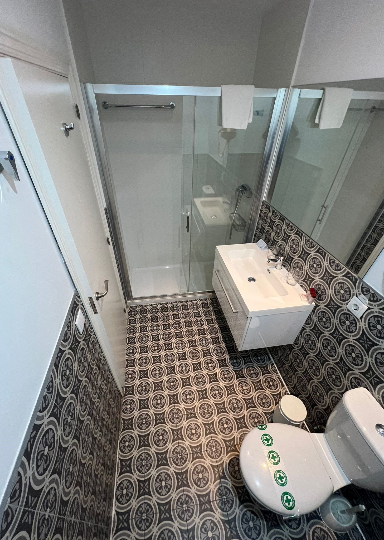 A bathroom with a shower, toilet, and sink.