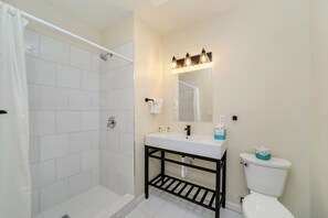 A bathroom with a shower, sink, and toilet.