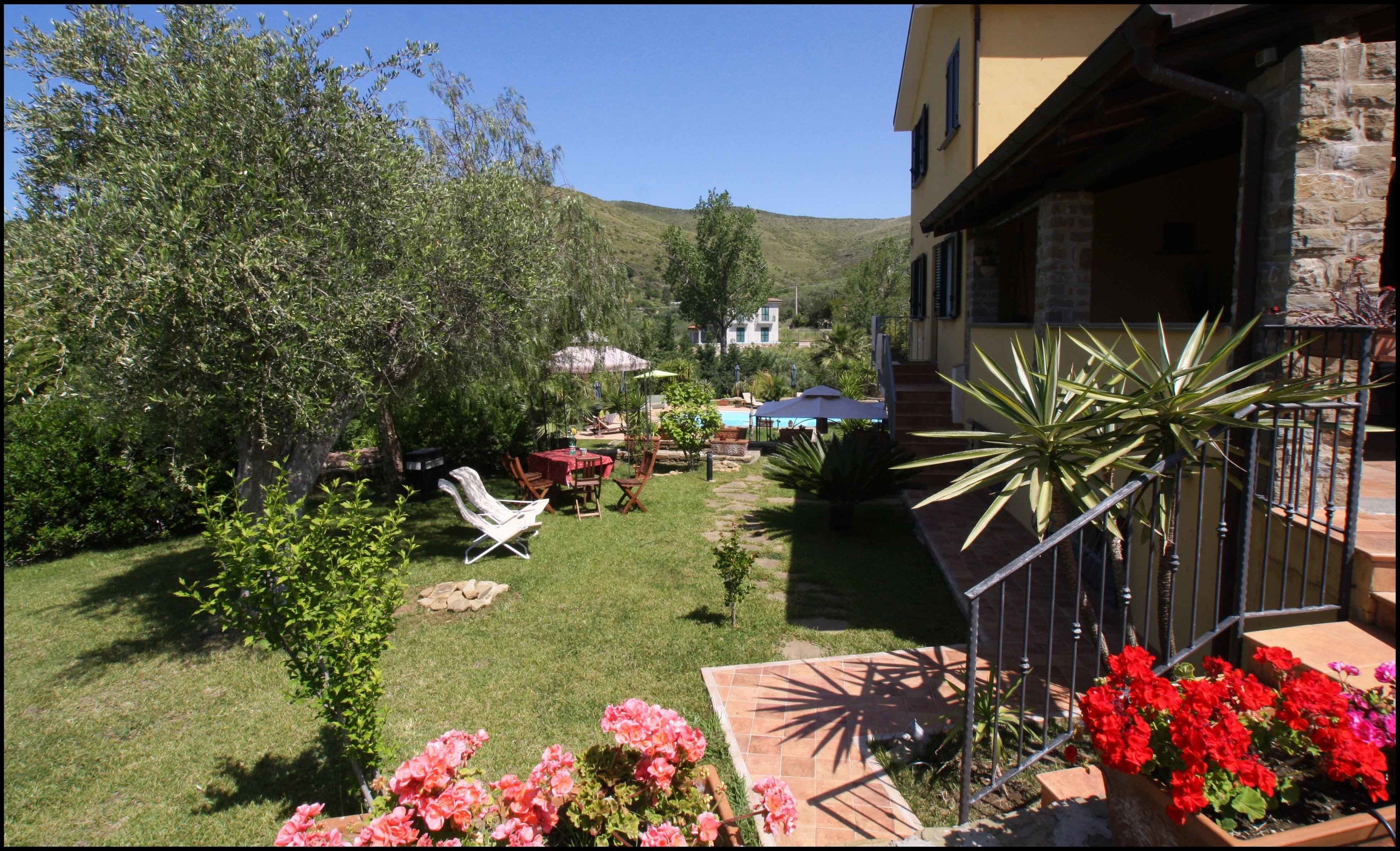 Un jardín con patio, mobiliario exterior y una piscina.