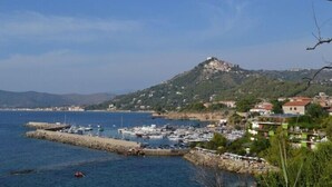 A coastal town with a marina, houses, and a hill with a castle-like structure. - Villa Tresino Appartamenti B&B (Castellabate)