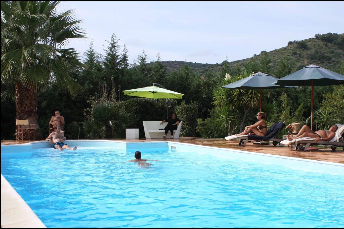 Ein Schwimmbad mit entspannten und sonnenden Menschen.