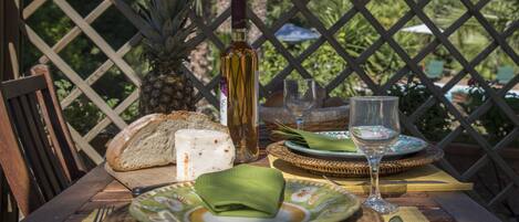 Una tavola imbandita con pane, una bottiglia, un bicchiere e un piatto con un tovagliolo.
