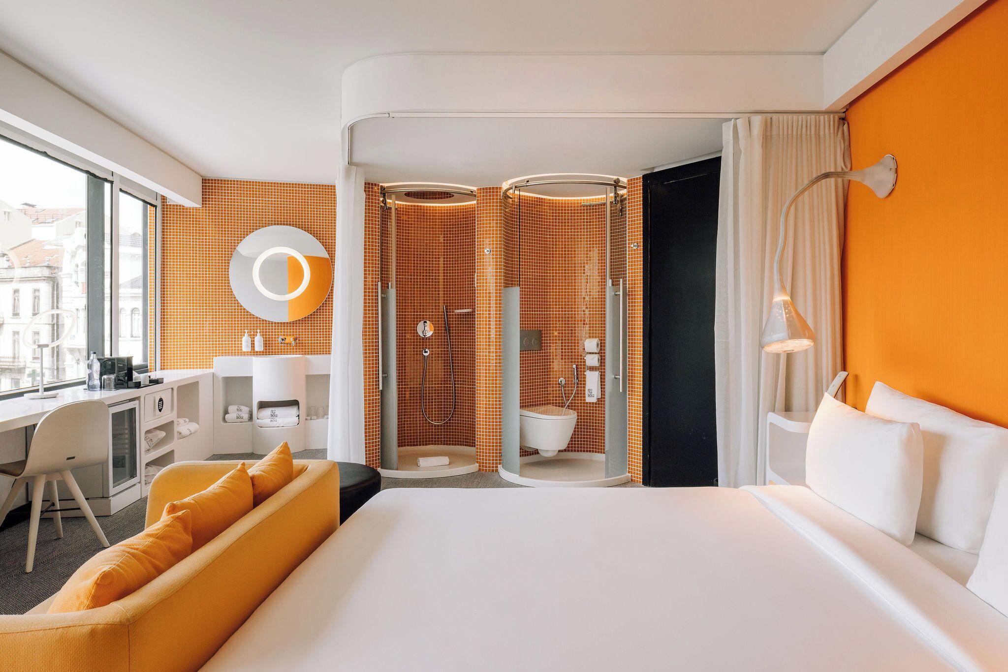 Une chambre d’hôtel comprenant un lit, un bureau, une chaise, un canapé, une douche et une salle de bain.