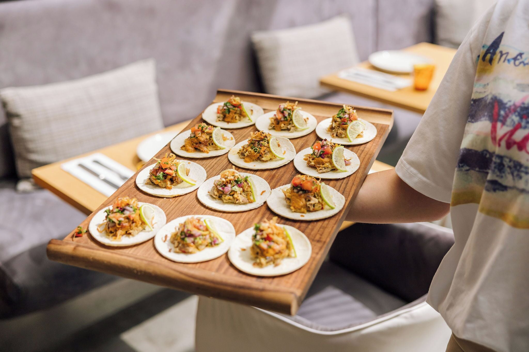 Una bandeja con varios tacos dispuestos sobre una tabla de madera.