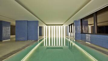 Una piscina techada, sillones reclinables de piscina
