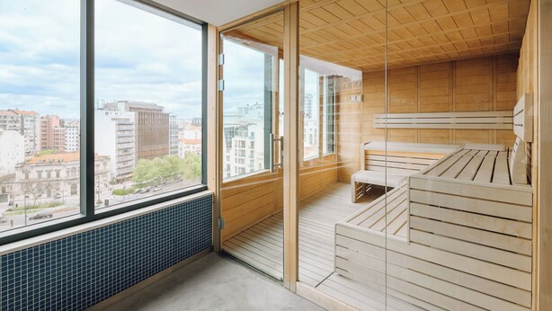 Una habitación moderna con ventanas amplias, techo de madera y un banco empotrado.