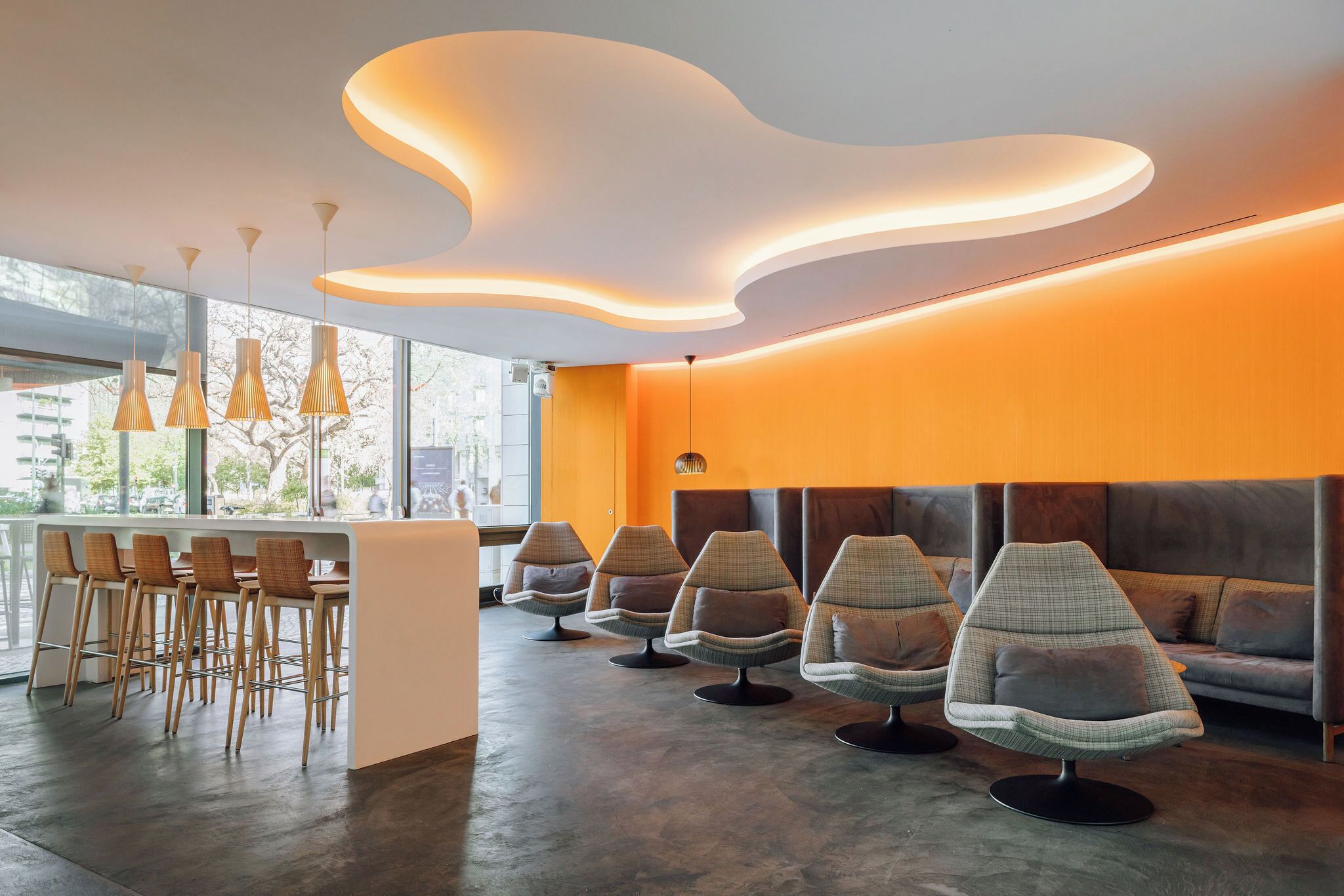 A modern interior with a bar area, seating, and a unique ceiling design.
