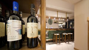 A wine rack with bottles labeled 'Syrah Salento' and 'Merlot'. - Hotel Italia Ristorante Pizzeria (Reggello)