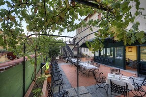 An outdoor patio with tables and chairs, a staircase, and a building in the background. - Hotel Italia Ristorante Pizzeria (Reggello)
