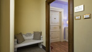 A hallway with a bench, a door, and a sign reading "NAVONA TOWER RELAIS". - Navona Tower Relais (Rome)
