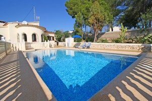 Una piscina al aire libre, sombrillas, tumbonas