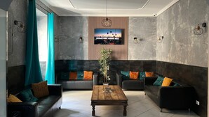 Un saló modern amb dos sofàs, una taula de centre i un televisor fixat a la paret.