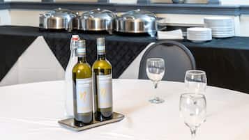 Una mesa con dos botellas de vino Pinot Grigio y dos copas de vino vacías.