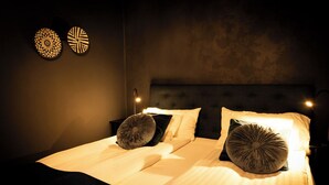 A neatly made bed with two pillows, a headboard, and two wall-mounted decorative items. - Hotell Aqva Restaurang & Bar – Ett Biosfärhotell med fokus på hållbarhet (Mariestad)