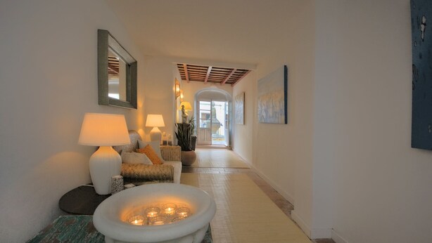 A hallway with a sofa, two lamps, a decorative bowl with candles, and a mirror on the wall. - Benali Guesthouse (Tarifa)