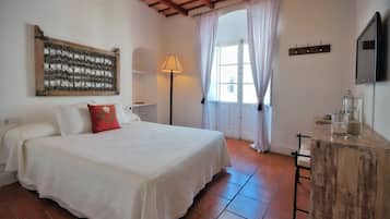Cozy retreat with a large bed, nightstand, and flat-screen TV.