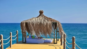 A wooden pier leading to a thatched-roof structure with a view of the ocean. - Selectum Family Comfort Side (Manavgat)