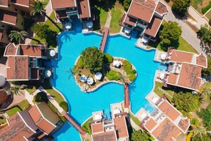An aerial view of a resort with a central swimming pool surrounded by villas, palm trees, and a well-maintained lawn. - Selectum Family Comfort Side (Manavgat)