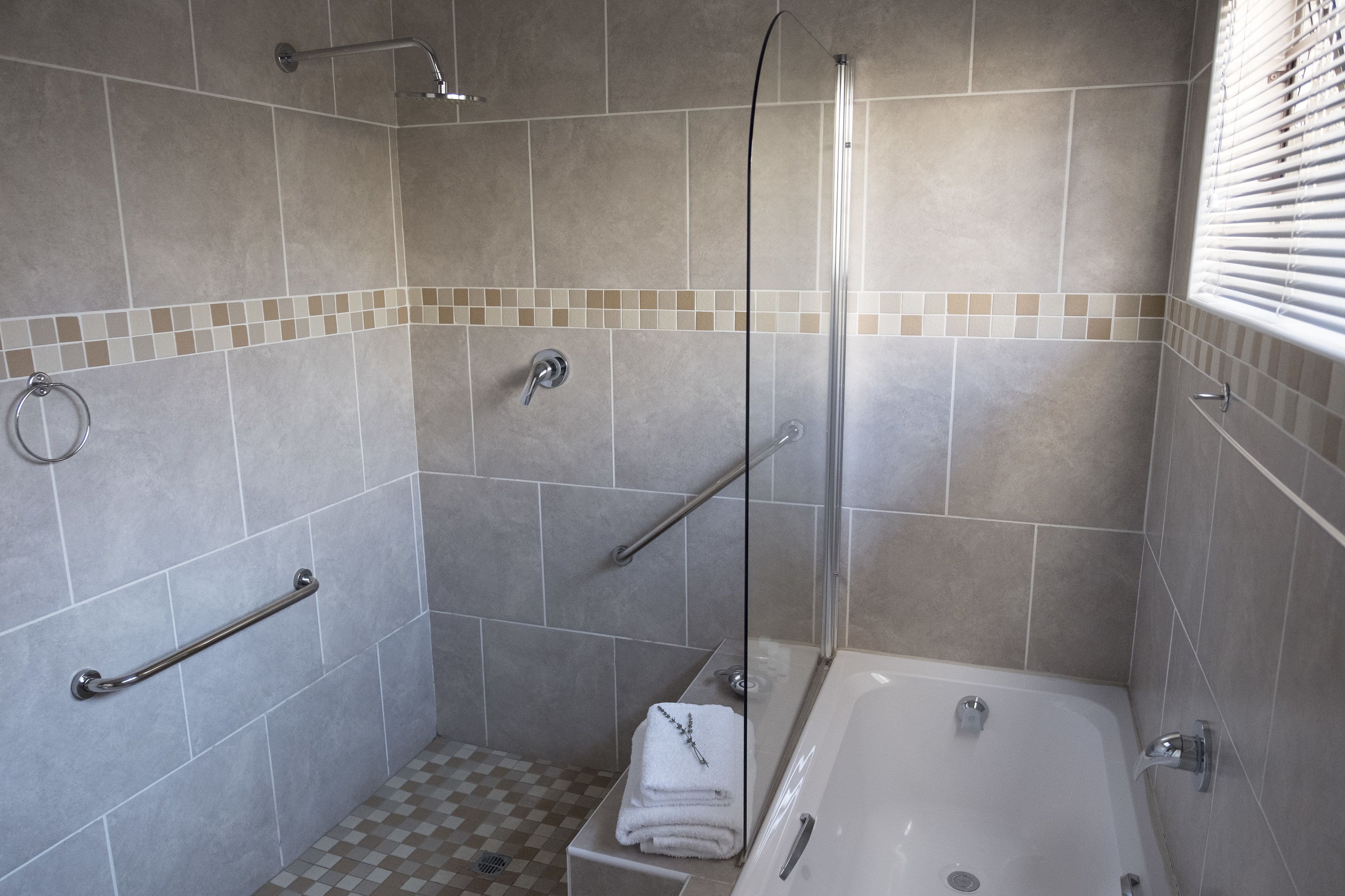 Un baño con ducha, bañera y retrete.