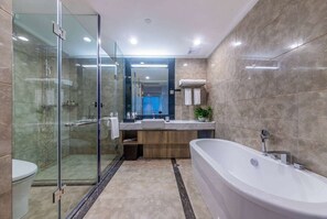 Ein modernes Badezimmer mit einer gläsernen Duschkabine, einer freistehenden Badewanne und einem Waschtisch mit Spiegel.