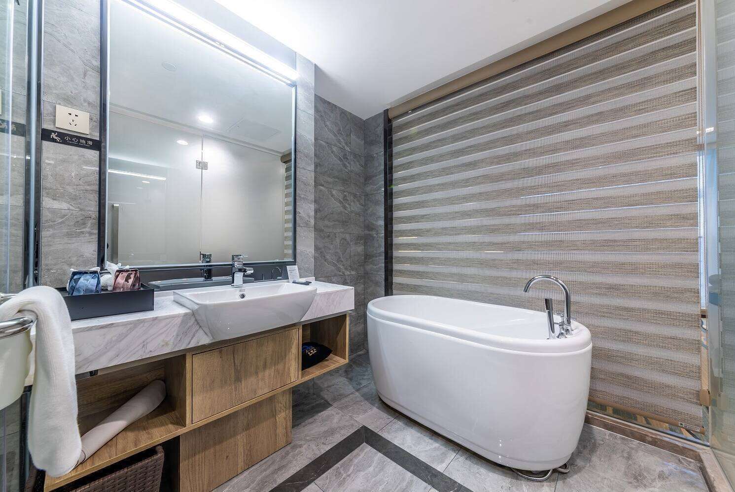 Ein modernes Badezimmer mit großem Spiegel, zwei Waschbecken und einer freistehenden Badewanne.
